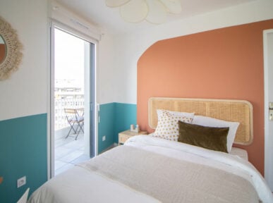 chambre à louer à Lyon (69) par Colivys, mur orange, mur bleu, lit chaleureux, porte fenêtre avec accès sur balcon