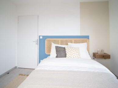 Chambre à louer à Lyon (69) par Colivys, mur bleu et beige, lit de chambre, tête de lit en bois, porte blanche