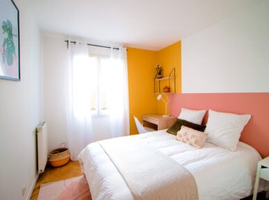 Chambre à louer à Saint Denis par Colivys, mur jaune, tête de lit rose, décoration moderne, placard blanc
