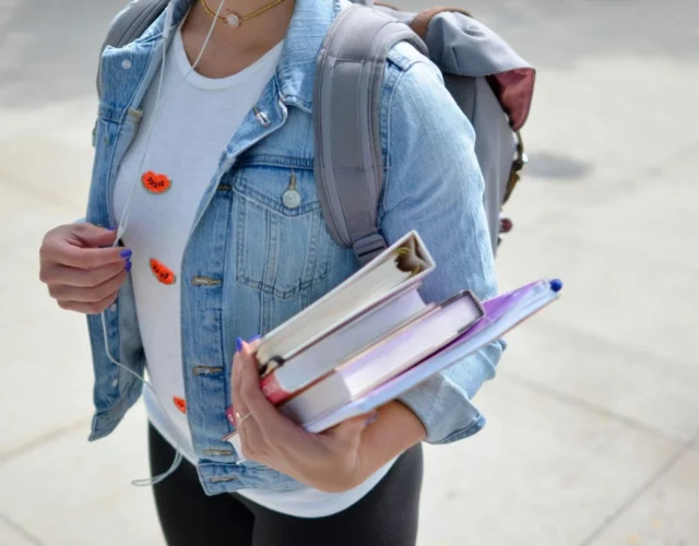 Student with books on her way to university illustrating the student accommodation parcoursup article