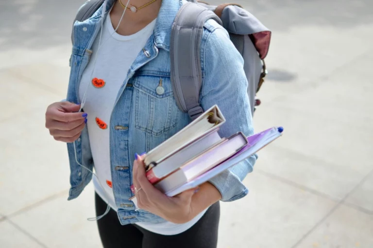 Student with books on her way to university illustrating the student accommodation parcoursup article