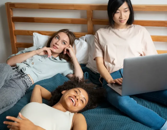 Coliving Interns - Image of roommates chilling and working on a bed