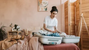 Coliving move-in checklist- Woman packing suitcase for trip