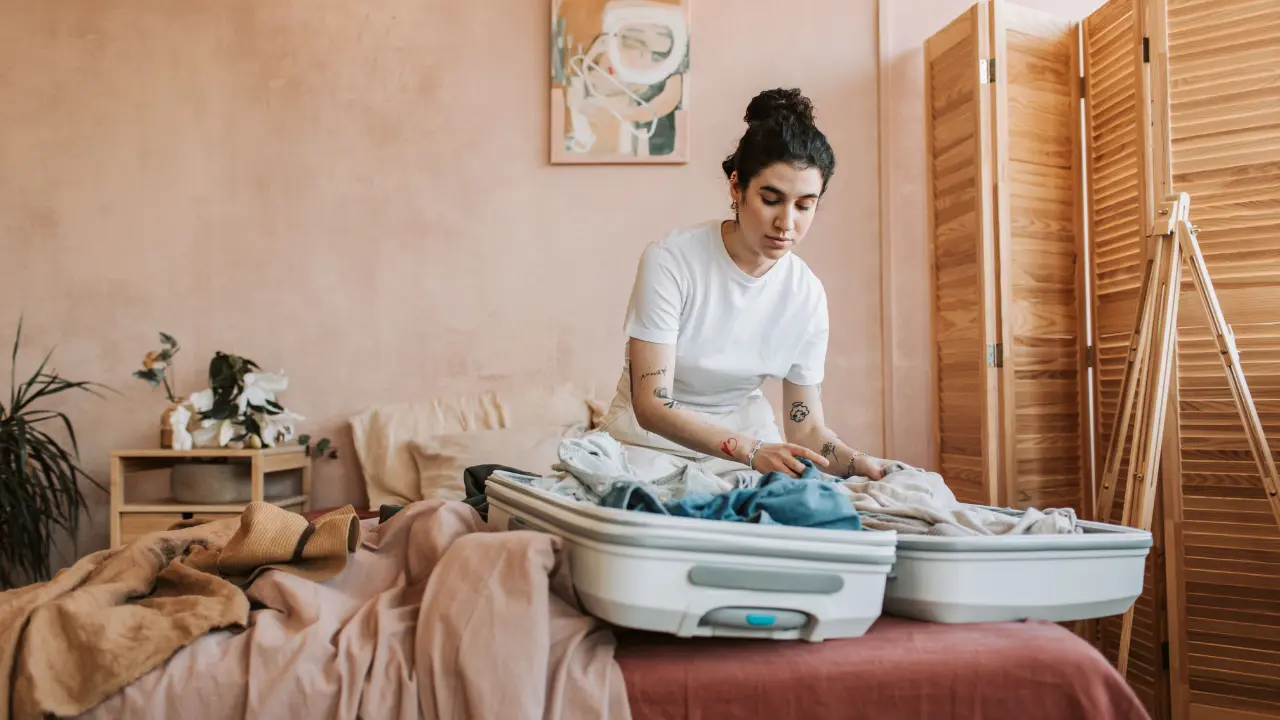 Coliving move-in checklist- Woman packing suitcase for trip